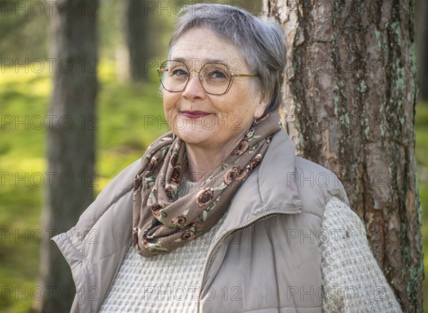 Portrait of elderly woman, 65 years old, enjoying nature in the forest in Ystad, Skåne, Sweden, Scandinavia, Europe