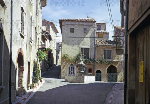 Attractive historic buildings in the village street of Venasque, Vaucluse, Provence, France 1974