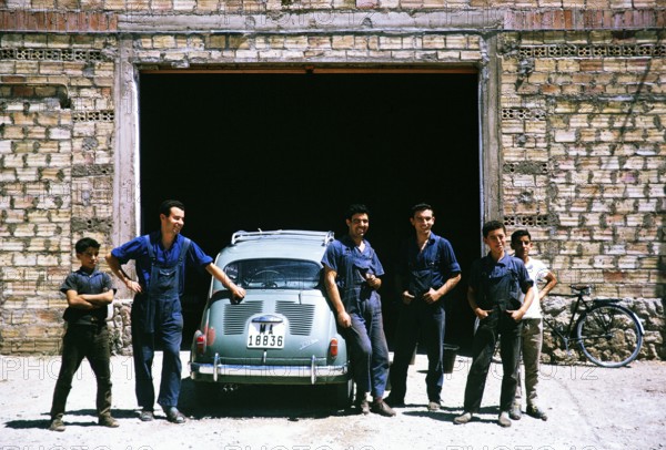 Mechanics standing next to a SEAT 600 car, Spain 1964