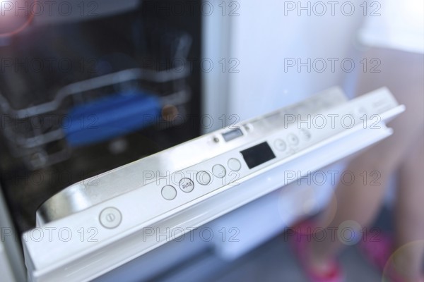 Dishwasher door partly open, showing control panel buttons
