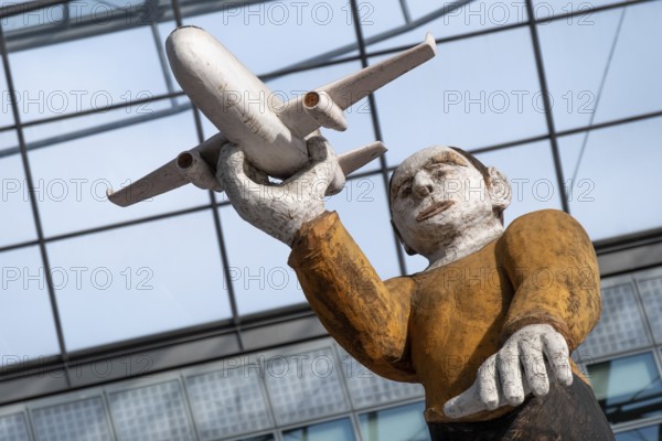 Sculpture, wooden figure with aeroplane at Munich Airport, Terminal 2, Munich, Bavaria, Germany, Europe