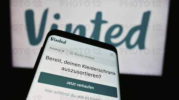 Stuttgart, Germany, 03-17-2024: Mobile phone with website of online secondhand marketplace company Vinted in front of business logo. Focus on top-left of phone display, Europe