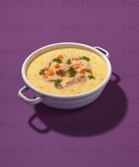 Traditional greek chicken soup in a white enamel bowl, isolated on a purple background