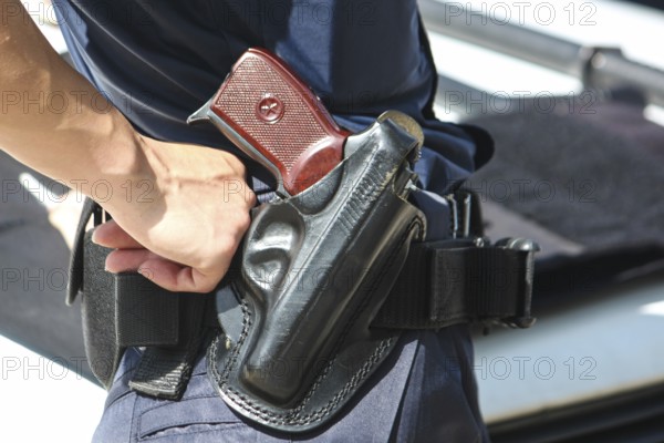 A woman's hand touches a body and a gun. Woman with a gun. Woman policemen with gun in a black holster. Makarov gun in a police holster. Profession, a job that saves lives. Profession police officer. Bulgaria