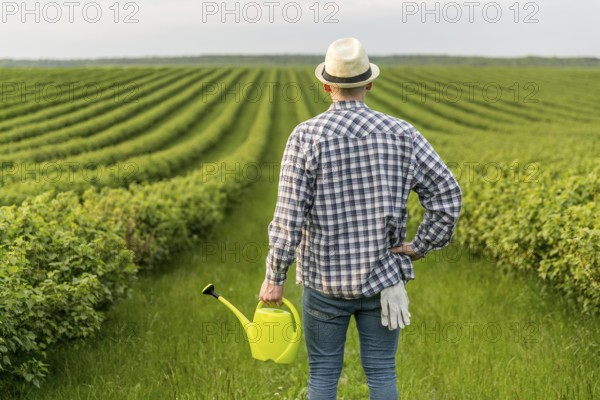Man farmland with watering can