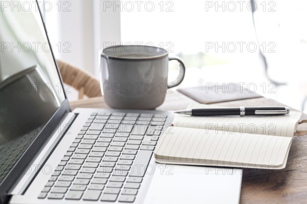 notepad and ballpoint pen on laptop computer, work from home concept