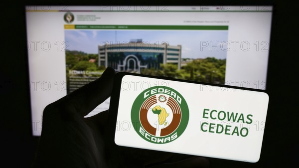 Stuttgart, Germany, 02-15-2024: Person holding smartphone with logo of Economic Community of West African States (ECOWAS) in front of website. Focus on phone display, Europe
