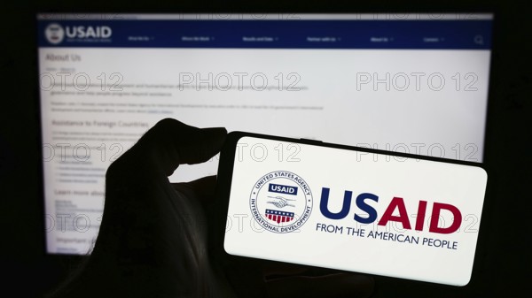 Stuttgart, Germany, 11-27-2023: Person holding cellphone with logo of United States Agency for International Development (USAID) in front of webpage. Focus on phone display, Europe