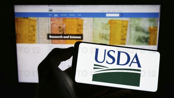 Stuttgart, Germany, 12-11-2022: Person holding cellphone with logo of United States Department of Agriculture (USDA) on screen in front of webpage. Focus on phone display, Europe