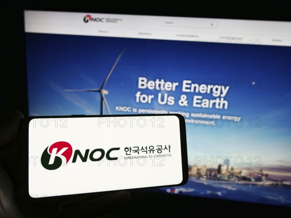Stuttgart, Germany, 11-16-2023: Person holding smartphone with logo of petroleum company Korea National Oil Corporation (KNOC) in front of website. Focus on phone display, Europe