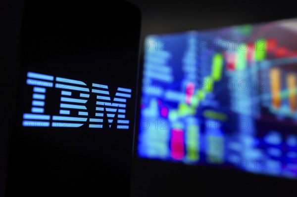 March 15, 2024, Brazil. In this photo illustration, the International Business Machines Corporation (IBM) logo is displayed on a smartphone screen, with graphic representation of the stock market in the background