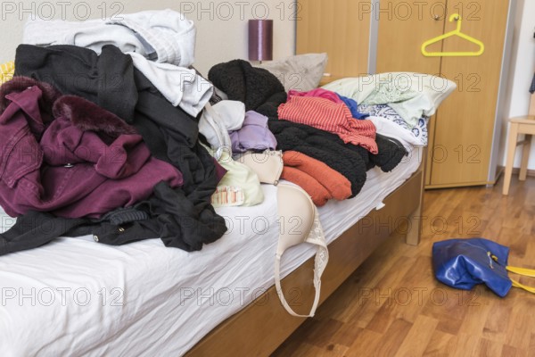 Messy teenager room. Untidy cluttered bed, dirty clothes. Compulsive Hoarding Syndrom