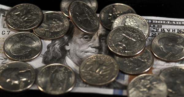 Quarter Dollar Coins Falling, Rolling and Sliding on Black Background