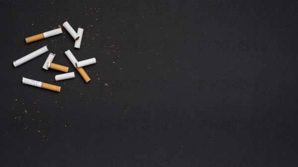 Top view broken cigarette with tobacco black backdrop