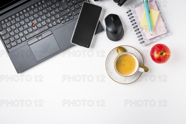 Working place and office desk with coffee, laptop, apple, headset and smarthpone. Flatlay in black tone