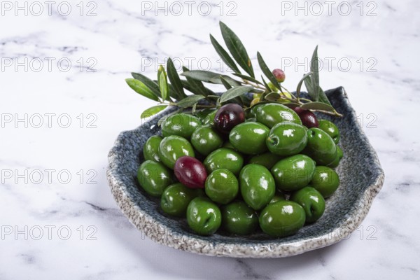 Chalkidiki olives, classic Greek green olives, in a plate, top view, no people