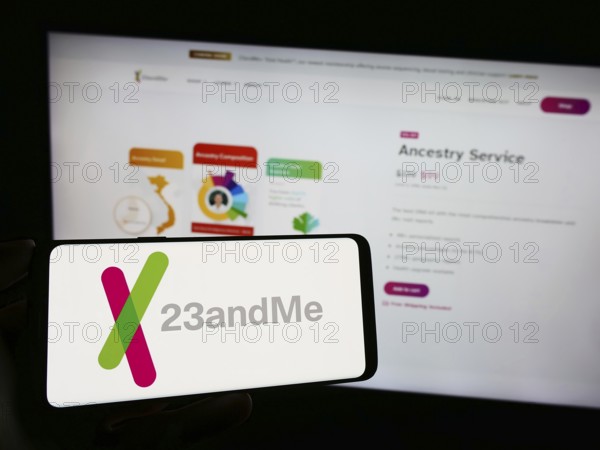 Stuttgart, Germany, 11-03-2023: Person holding cellphone with logo of US biotechnology company 23andMe Inc. in front of business webpage. Focus on phone display, Europe