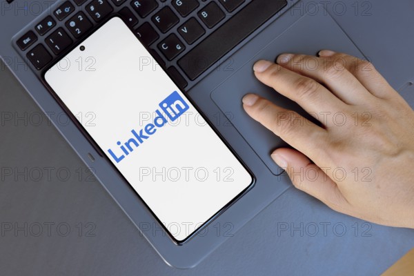 In this photo illustration, the LinkedIn logo is displayed on a smartphone screen