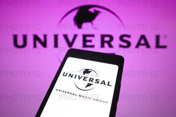 In this photo illustration, the Universal Music Group logo is displayed on a smartphone screen and in the background