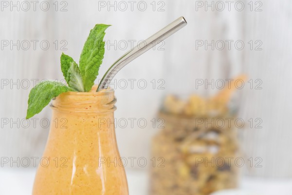 Seasonal pumpkin carrot smoothie drink detox with eco metal drinking straw Glass jar granola muesli oatmeal breakfast. Orange smoothie. Clean eating, weight loss, healthy dieting food concept Fruit vegetable drink fitness