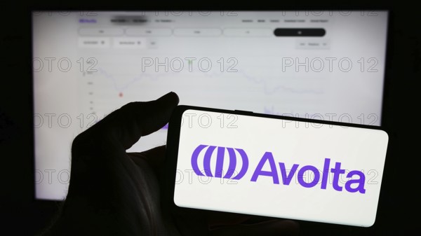 Stuttgart, Germany, 05-31-2024: Person holding mobile phone with logo of Swiss travel retail company Avolta AG in front of business web page. Focus on phone display, Europe