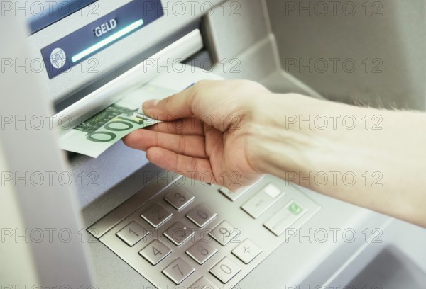 Young woman withdrawing money from a cash machine
