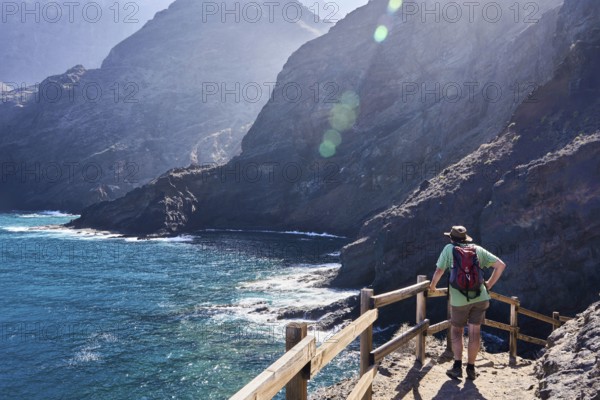Hikers on the hiking trail from Playa de la Caleta to Punta San Lorenzo, cliffs near Hermigua, La Gomera, Canary Islands, Spain, Europe