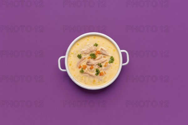 Top view with a bowl of chicken soup, greek recipe with lemon juice and vegetables