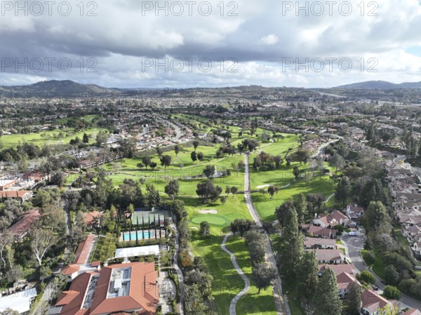 Aerial view of residential neighborhood surrounded by golf and valley during cloudy day in Rancho Bernardo, San Diego County, California. USA
