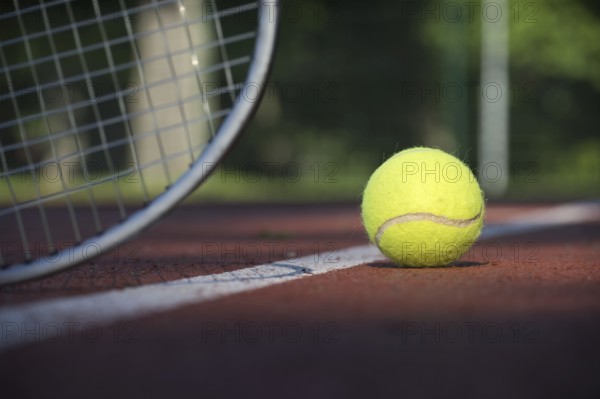 Low angle view tennis scene with yellow ball near racquet and white line in a sports and healthy lifestyle concept