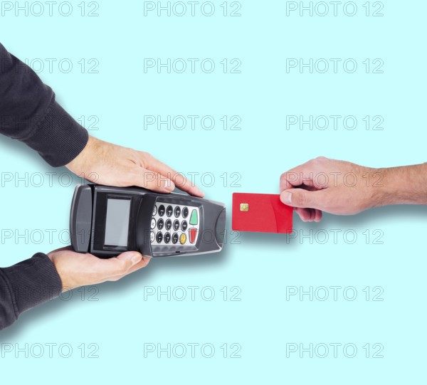 top view of person paying using credit card or debit card, holding card against credit card reader