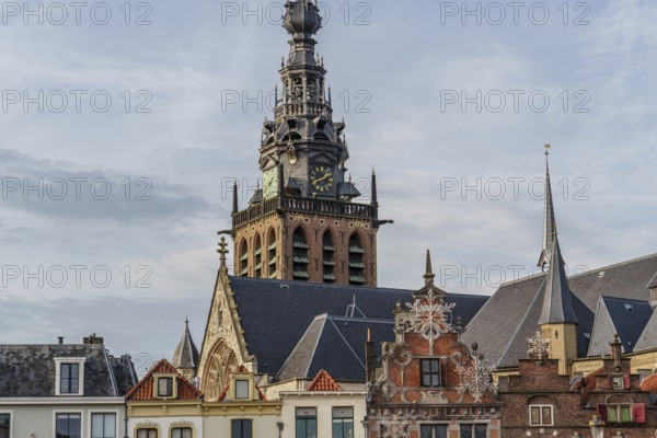 View of church tower and roofs of historic buildings under a cloudy sky, nijmegen, waal, gelderland, netherlands