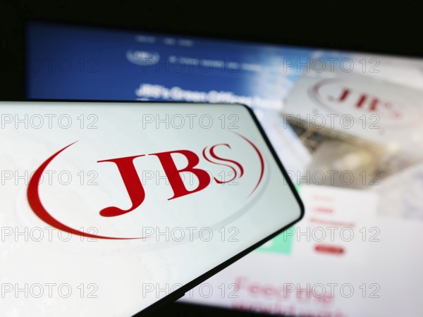 Stuttgart, Germany, 09-17-2023: Smartphone with logo of Brazilian mear processing company JBS SA on screen in front of website. Focus on center-left of phone display, Europe