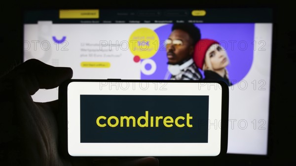 Stuttgart, Germany, 07-15-2024: Person holding cellphone with logo of German financial services company Comdirect in front of business webpage. Focus on phone display, Europe