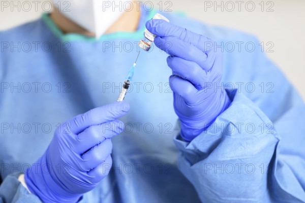 Doctor holding a syringe with a single bottle vial of Covid-19 vaccine. Concept fight against virus. Close up detail. Medical concept vaccination hypodermic injection treatment. High quality photo