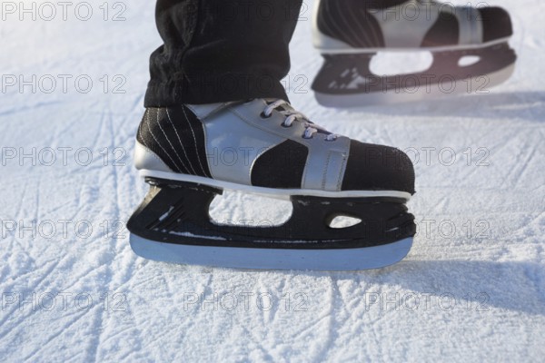 Adult Men's Ice Skates close-up on Ice in Winter outdoor on the move. Rolling and sliding in frosty sunny day, active winter sports and lifestyle