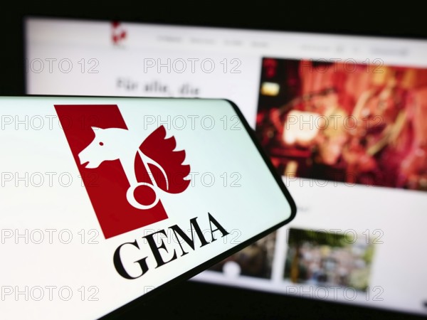 Stuttgart, Germany, 12-14-2023: Cellphone with logo of German collecting society GEMA in front of website. Focus on center-right of phone display, Europe