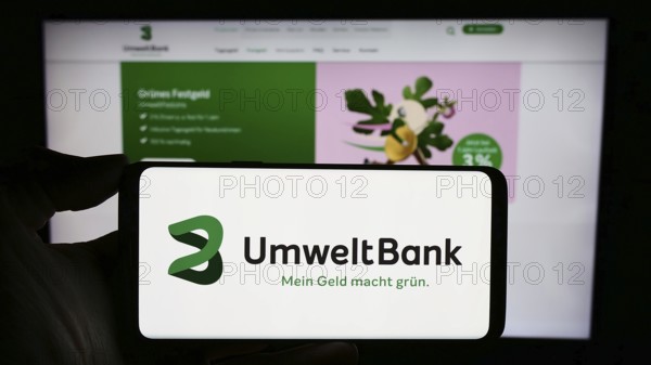 Stuttgart, Germany, 02-12-2024: Person holding cellphone with logo of German financial services company Umweltbank AG in front of business webpage. Focus on phone display, Europe