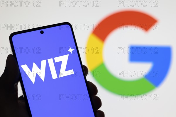 In this photo illustration, the Wiz logo seen displayed on a smartphone screen and the Google logo in the background
