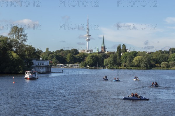 Leisure activities in summer, pedal boats and Alster-Touristik barge Susebek in front of a blue sky on the Alster, behind it the television tower Telemichel, Hamburg, Germany, Europe