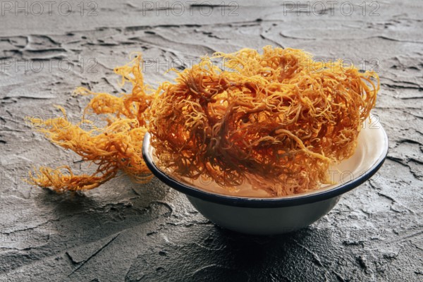Irish sea moss, Chondrus Crispus, healthy organic raw seaweed, dried, in a bowl on a black slate background