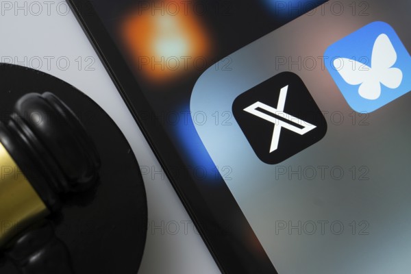 A close up of an iPad screen displaying the twitter (X) and bluesky app alongside a judge's gavel