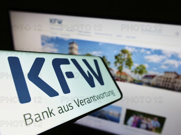 Stuttgart, Germany, 06-10-2022: Smartphone with logo of German bank Kreditanstalt für Wiederaufbau (KfW) on screen in front of website. Focus on centre-left of phone display, Europe