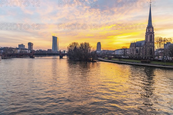 View across the River Main to the ECB and the Protestant Church of the Epiphany. Sunrise in the background of the buildings. Taken in the morning in Frankfurt am Main