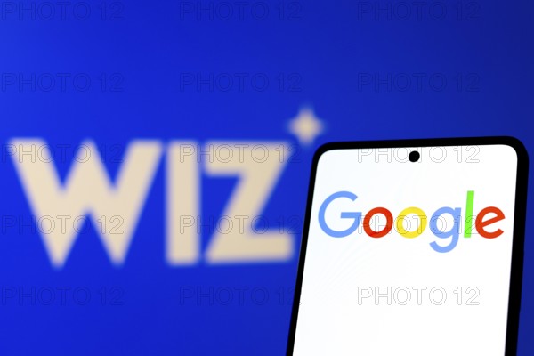 In this photo illustration, the Google logo is displayed on a smartphone screen, in the background the Wiz logo