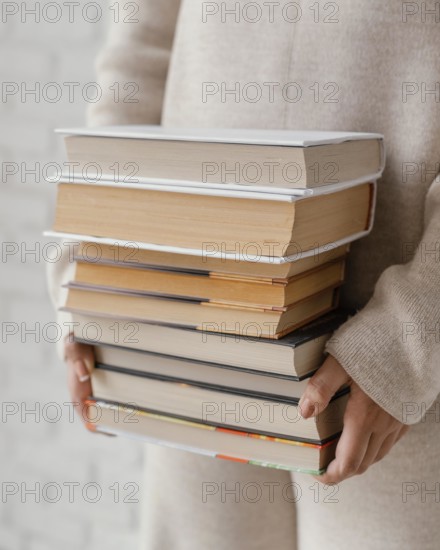 Close up hands holding books stack