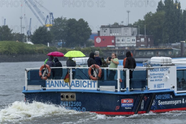 Symbolic picture weather, heavy rain in summer, thunderstorm, storm, tourists with umbrellas in the rain on a barge at the jetties in the harbour of Hamburg, Germany, Europe