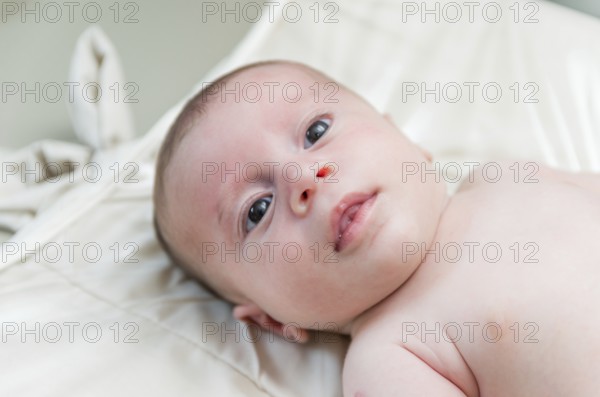 Beautiful happy newborn baby lying