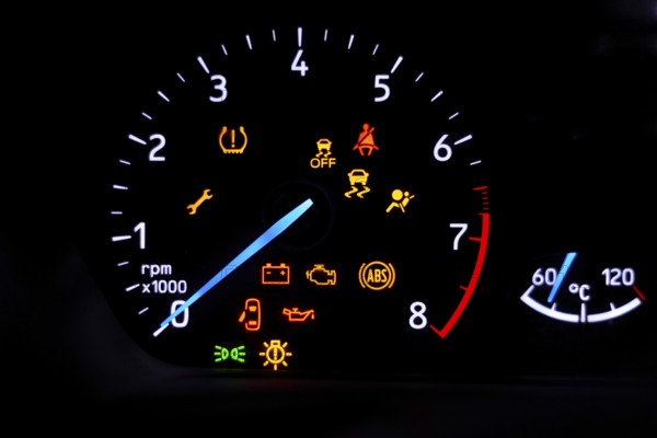 A car's dashboard lights up with multiple alert icons, signaling various vehicle functions and warnings in a clear, colorful display.