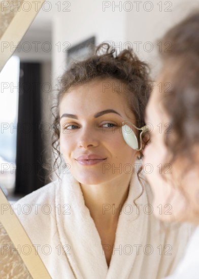 Woman looking mirror doing face massage 3